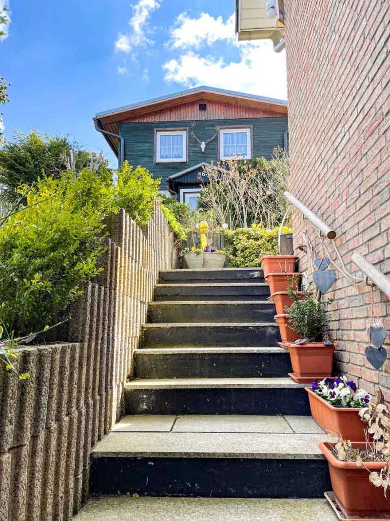 Treppenaufgang zum Ferienhaus mit Blumen am Geländer