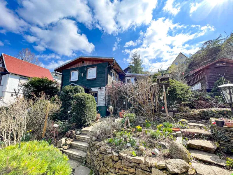 Ferienhaus mit Steinmauern, Treppe und blühendem Frühlingsgarten