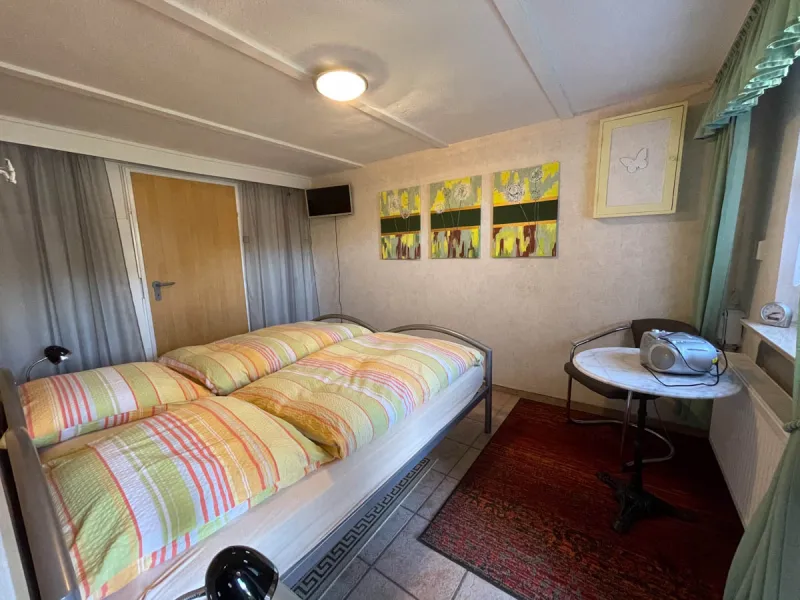 Zweites Schlafzimmer im Erdgeschoss mit Doppelbett und gemütlicher Sitzecke